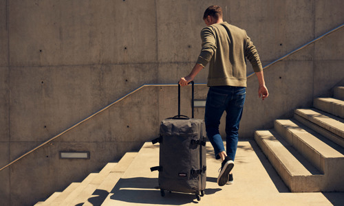 Mand med Eastpak softcase trolley på trapper