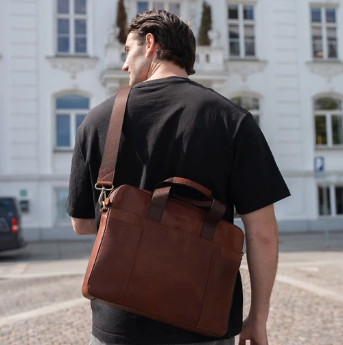 Ung mand med taske med plads til computer og bøger. Shop computertasker til studiet på neye.dk