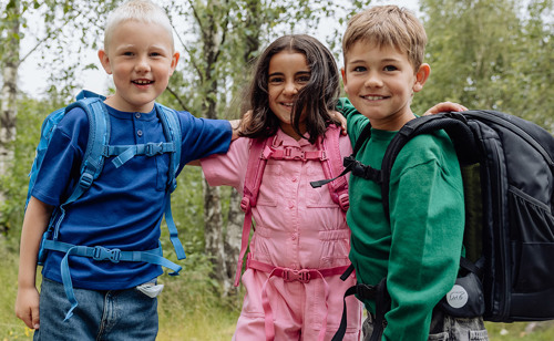 Børn med skoletasker. Se guiden til en god skolestart på neye.dk