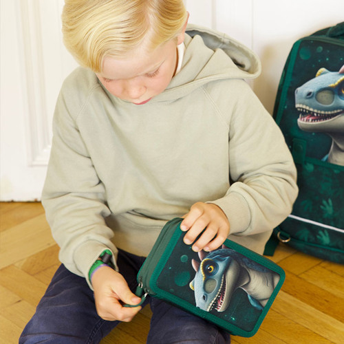 Dreng med penalhus og skoletaske med Dinosaur motiv. Shop Grow penalhuse på neye.dk