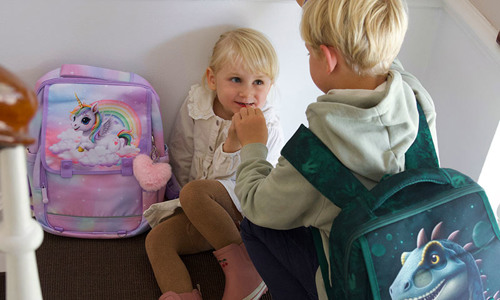 Pige med unicorn skoletaske og dreng med dinosaur skoletaske fra Grow.