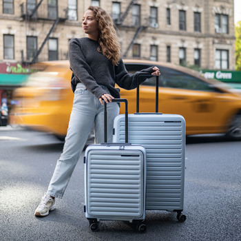 Kvinde med Samsonite Restackd kufferter. Se det store udvalg af Samsonite kufferter og rejsetilbehør på neye.dk