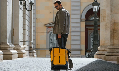 Mand mand med gul Samsonite Ecodiver kabinekuffert. Se det store udvalg af Samsonite kufferter på neye.dk